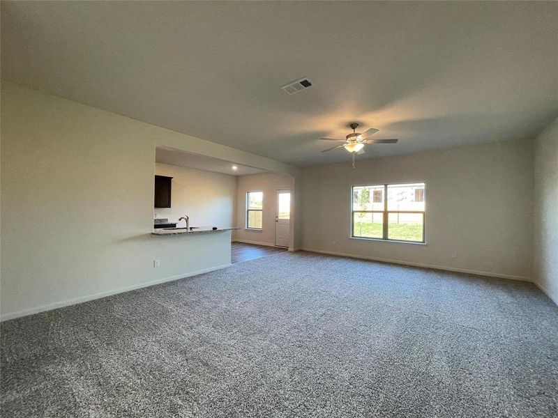 Empty room with carpet flooring, sink, and ceiling fan