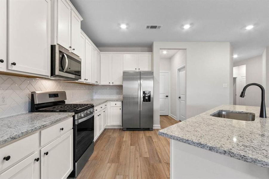 In this kitchen, white cabinets exude a sense of freshness and purity, perfectly paired with the luminous beauty of granite countertops. The open layout fosters a welcoming atmosphere, inviting conversation and interaction between the kitchen and living area.