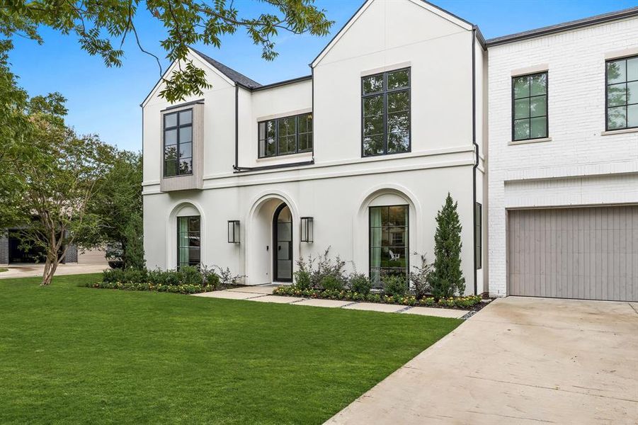 View of front of house featuring a garage and a front lawn