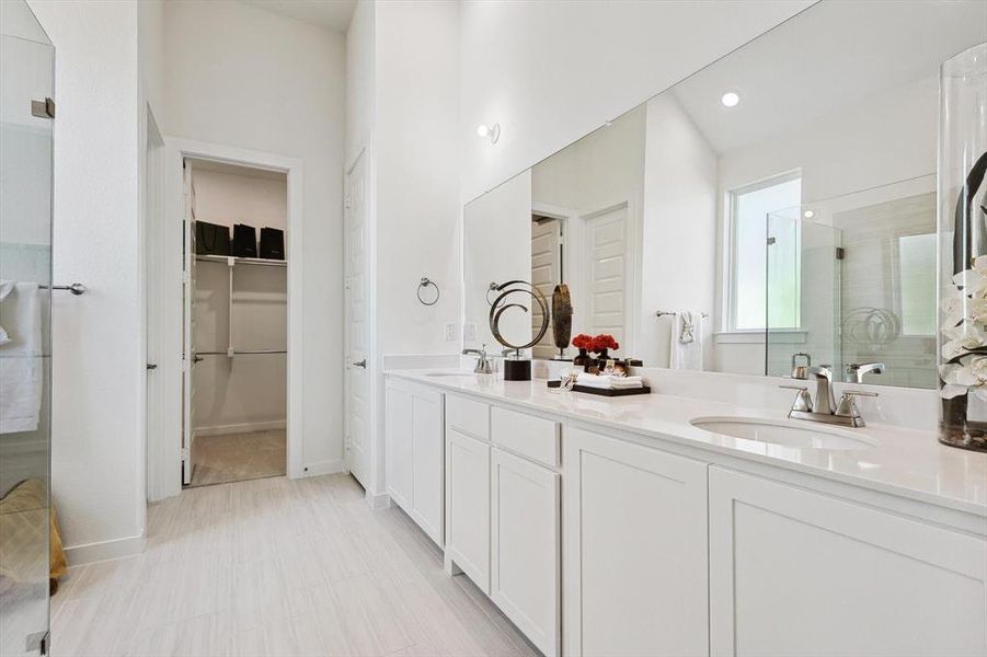 Bathroom featuring walk in shower, tile flooring, large vanity, and double sink