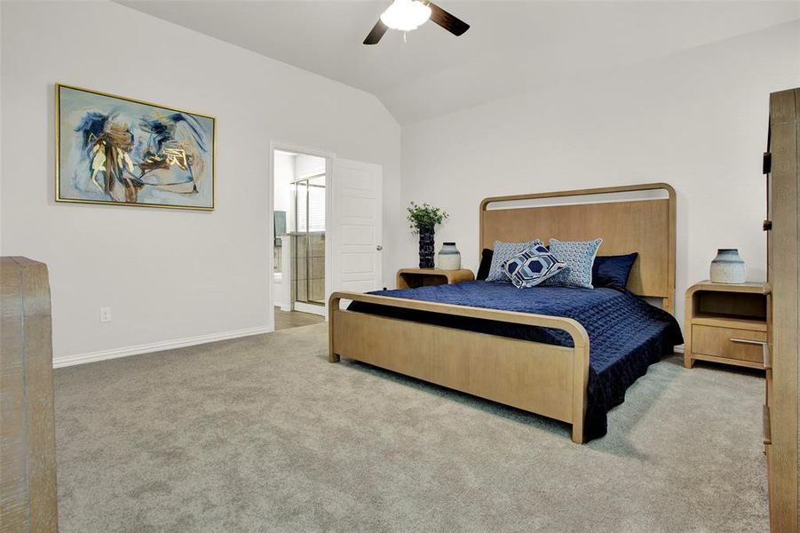 Bedroom with carpet, lofted ceiling, ceiling fan, and connected bathroom