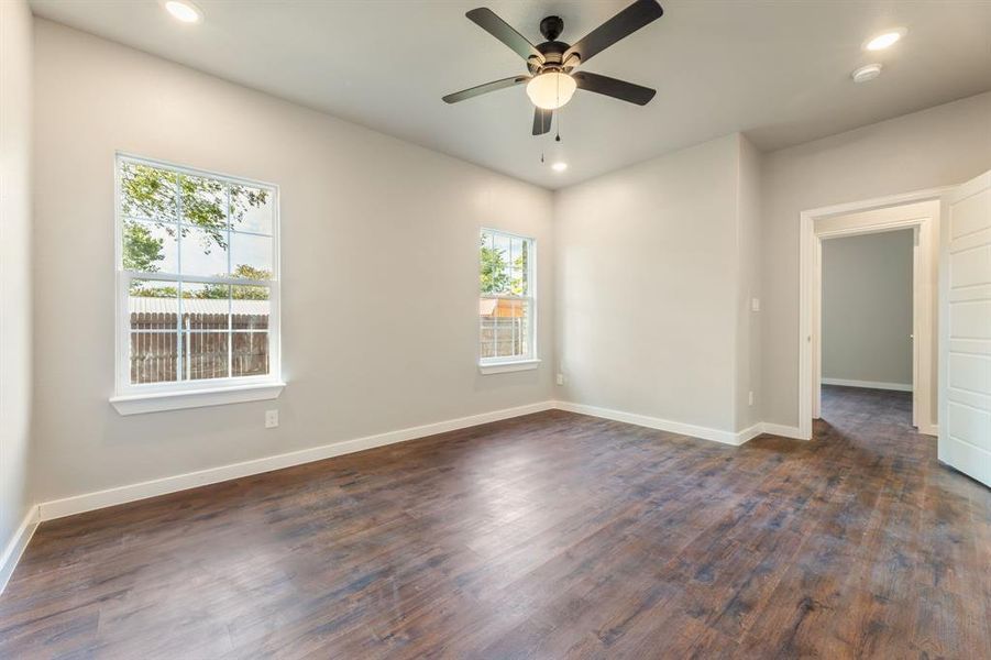 Empty room with dark hardwood / wood-style flooring and ceiling fan