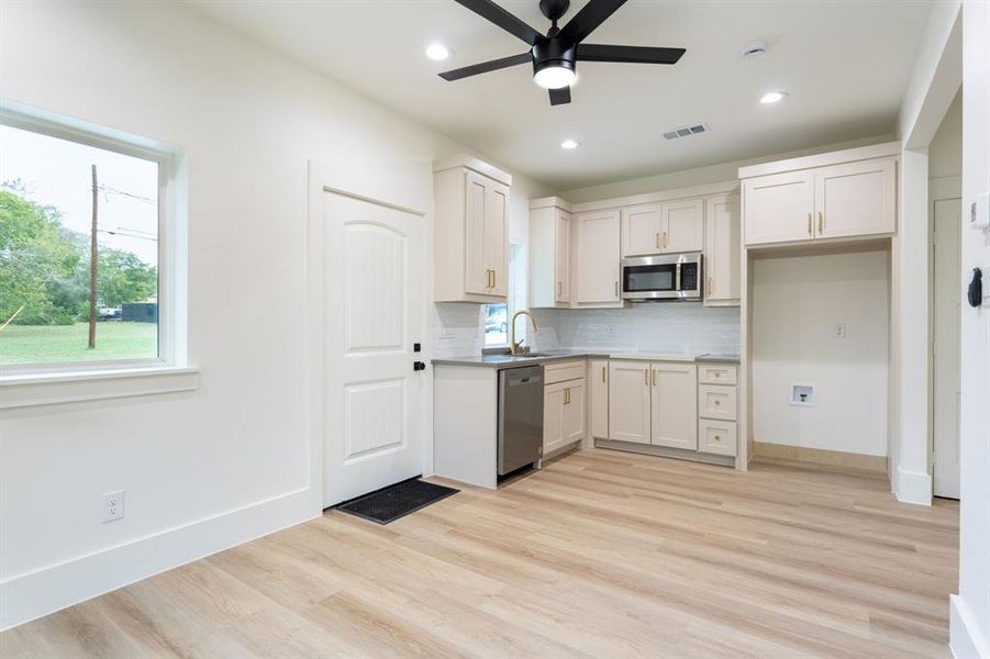 Kitchen featuring white cabinets, appliances with stainless steel finishes, and light hardwood / wood-style flooring