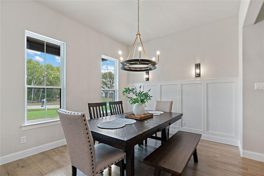 Dining area with a notable chandelier, wood-type flooring, and a wealth of natural light