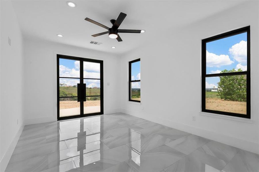 Bedroom room with ceiling fan, a wealth of natural light, and light tile patterned floors