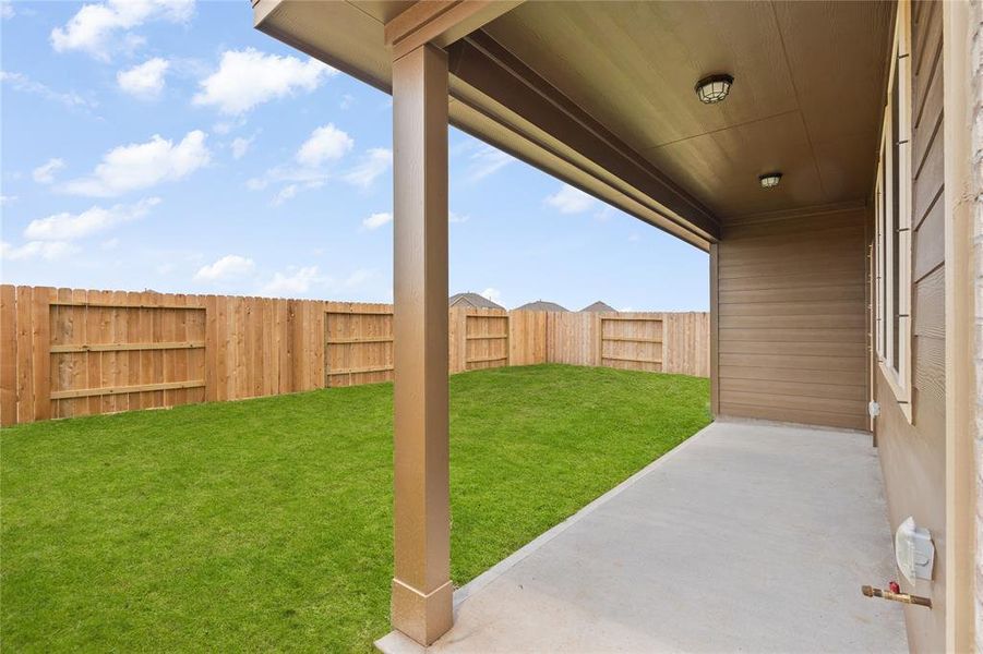 The covered patio is generously sized, providing ample space for various outdoor activities.