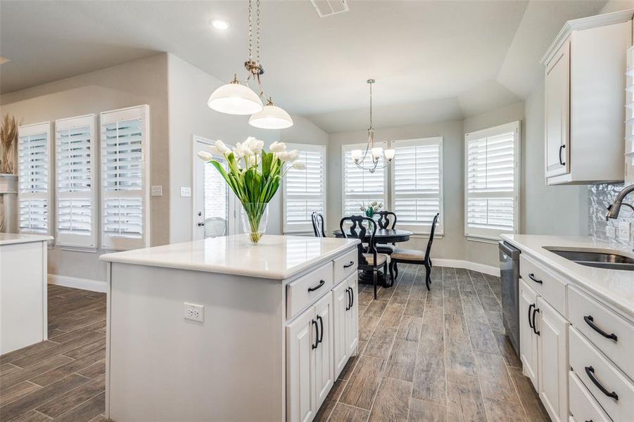 Kitchen with dishwashing machine, white cabinets, dark hardwood / wood-style flooring, a kitchen island, and sink