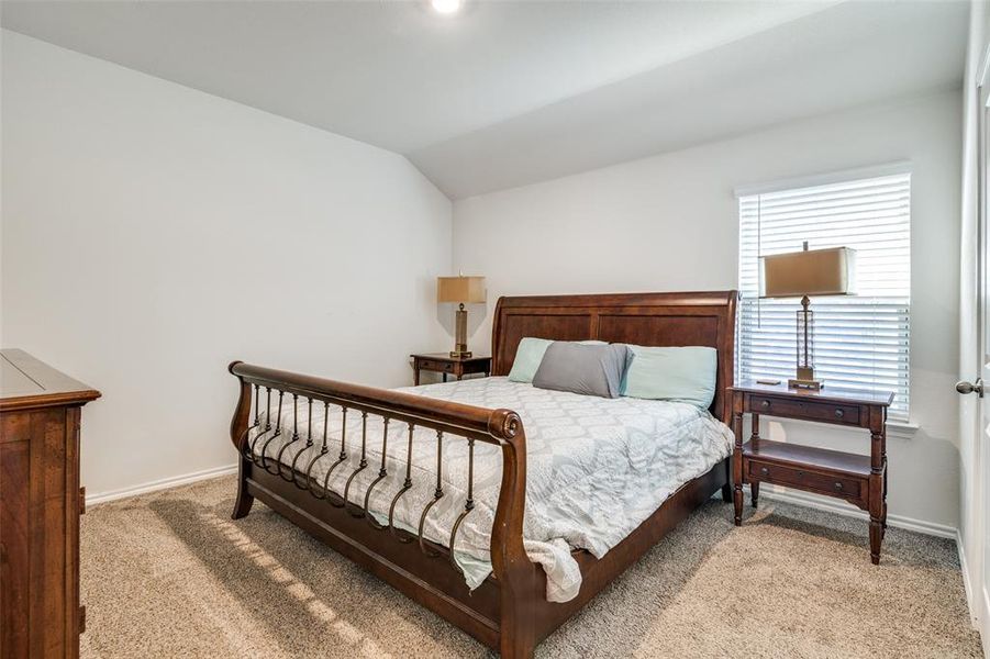 Bedroom with light carpet and vaulted ceiling