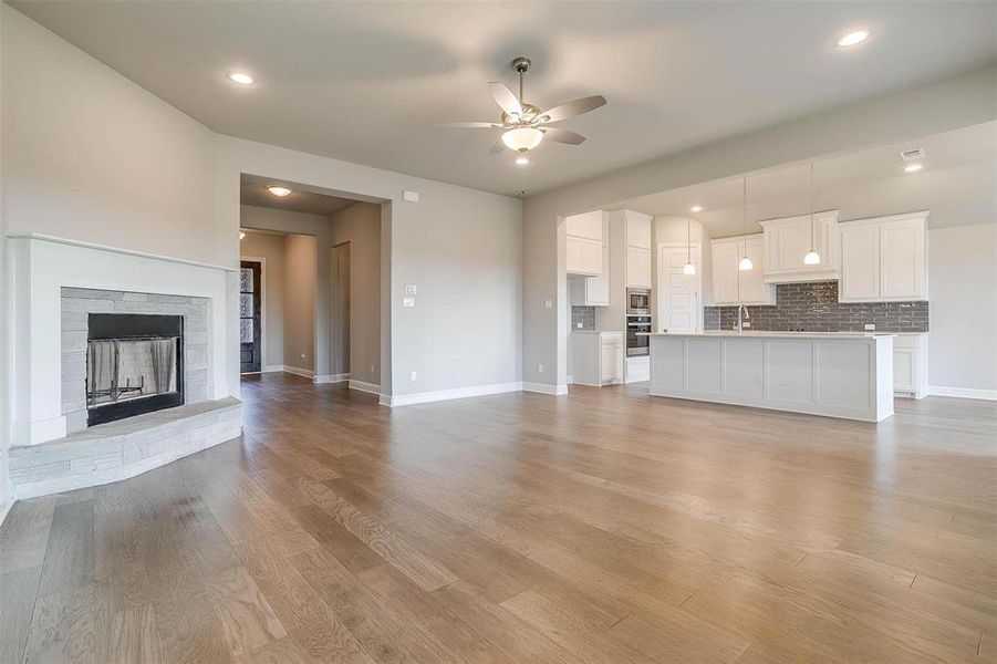 Unfurnished living room featuring light hardwood / wood-style floors, sink, and ceiling fan