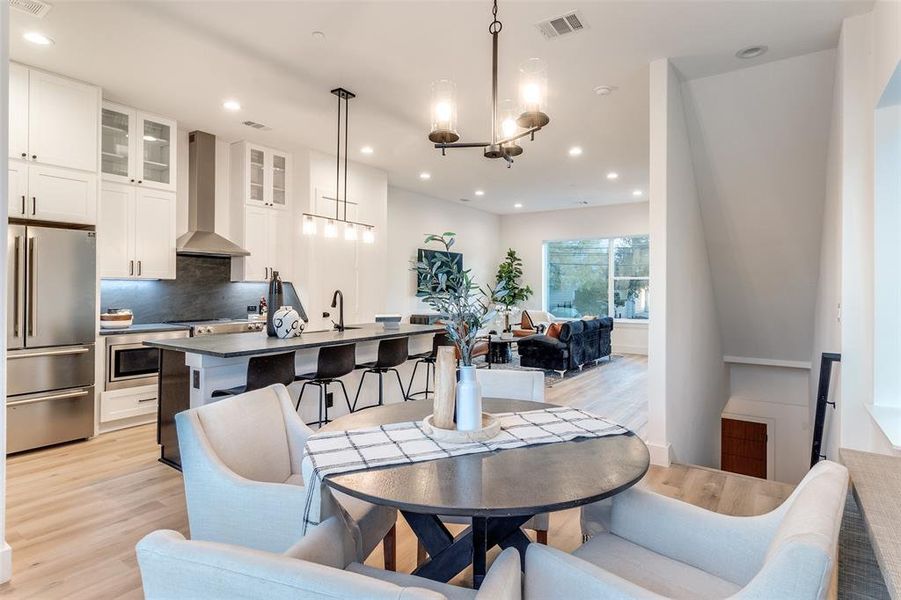 Dining space with light hardwood / wood-style flooring, a chandelier, and sink