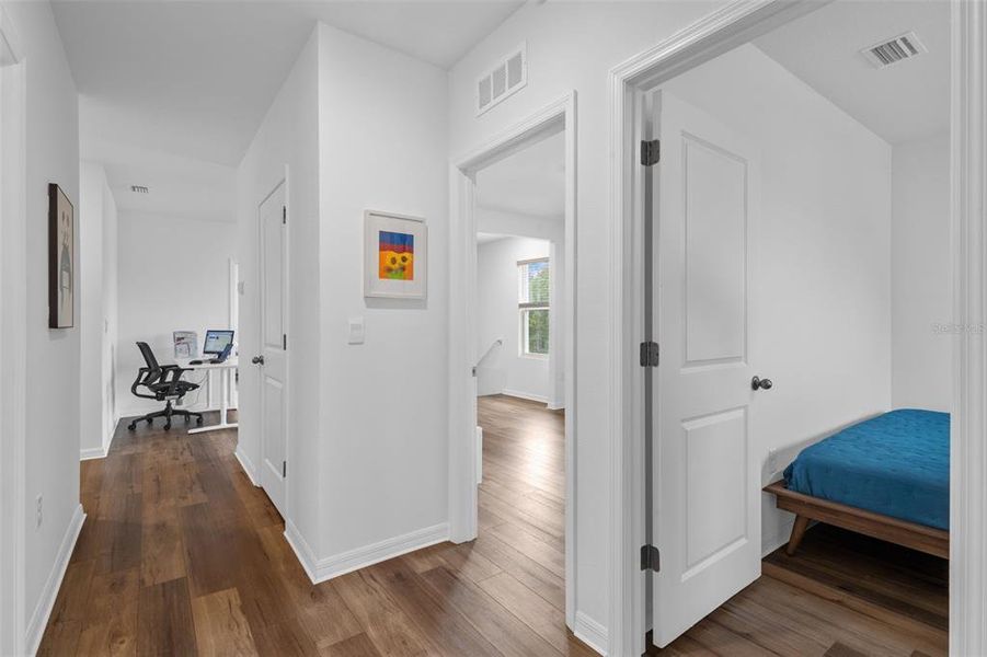 Hallway view from rear of home showing bedroom 4 to right and walkthrough to loft