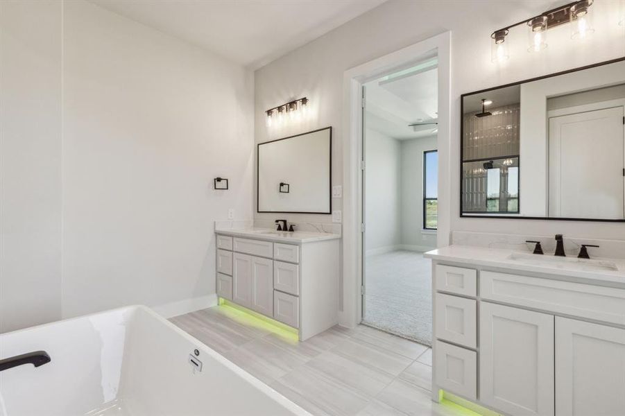 Bathroom with a tub to relax in, tile patterned flooring, and vanity