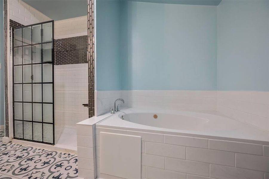 Bathroom featuring independent shower and bath and tile patterned flooring