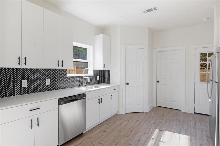 Kitchen featuring sink, a healthy amount of sunlight, light hardwood / wood-style floors, and appliances with stainless steel finishes