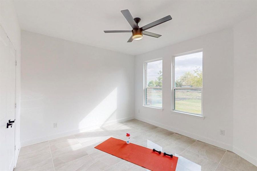 Unfurnished room featuring ceiling fan and light tile patterned flooring