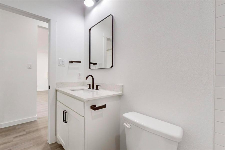 Bathroom featuring vanity, toilet, and hardwood / wood-style floors