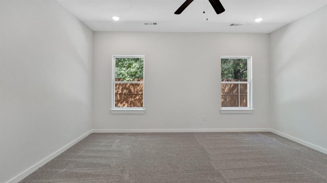 Empty room featuring ceiling fan and carpet floors