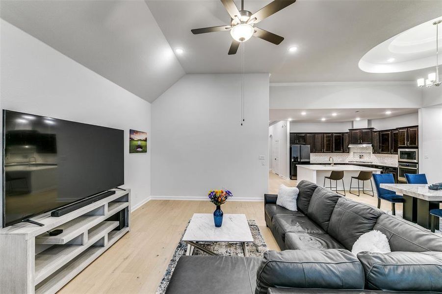 Living room with sink, high vaulted ceiling, light wood-type flooring, and ceiling fan