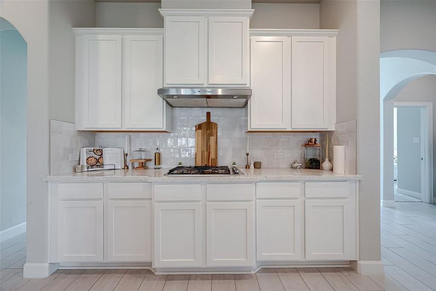 The kitchen has tile backsplash and a gas cooktop.