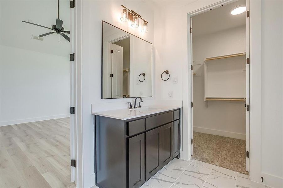 Bathroom featuring vanity, hardwood / wood-style flooring, and ceiling fan