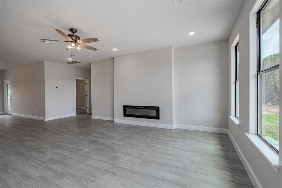 Unfurnished living room featuring ceiling fan and light hardwood / wood-style flooring