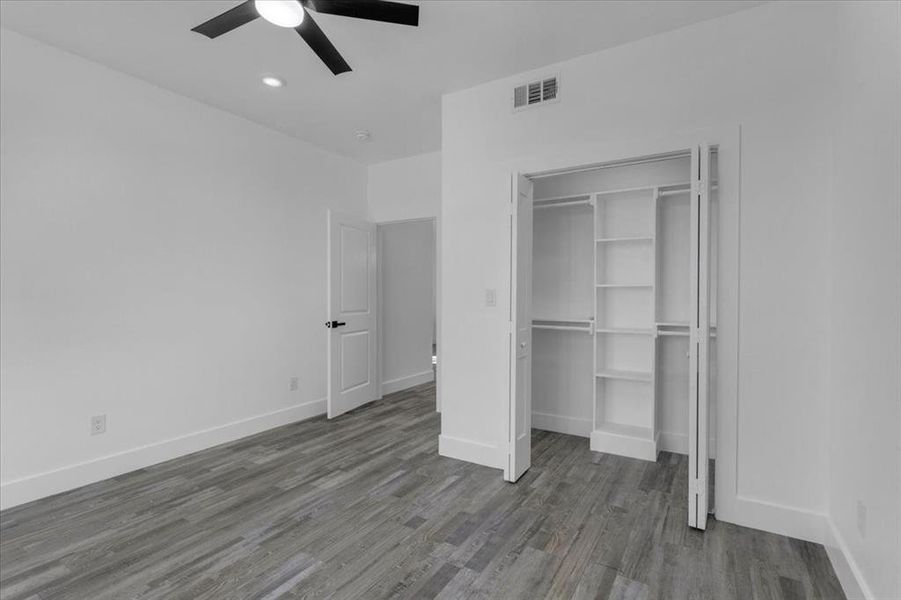 Unfurnished bedroom featuring hardwood / wood-style flooring, ceiling fan, and a closet