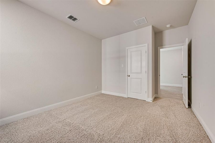 Unfurnished bedroom featuring light colored carpet