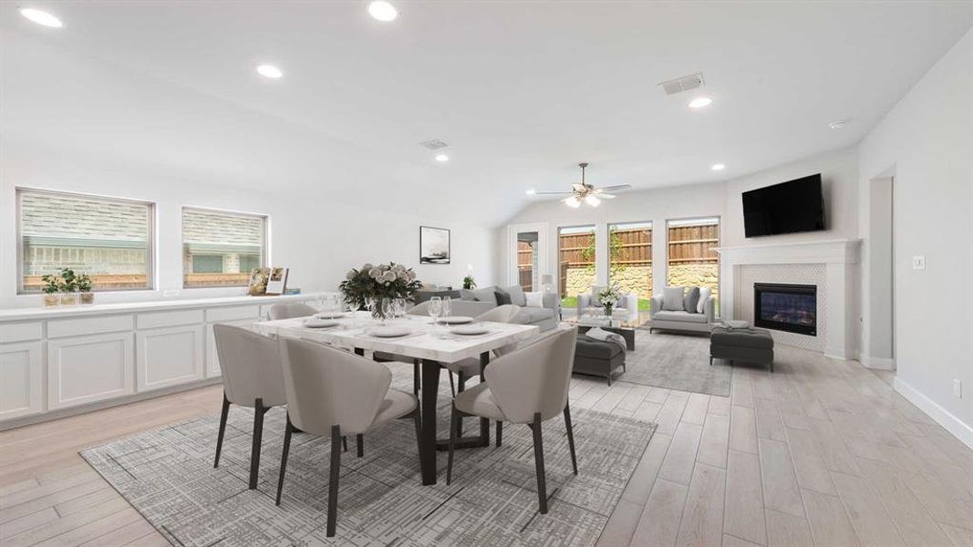 Dining space with lofted ceiling, light hardwood / wood-style flooring, and ceiling fan