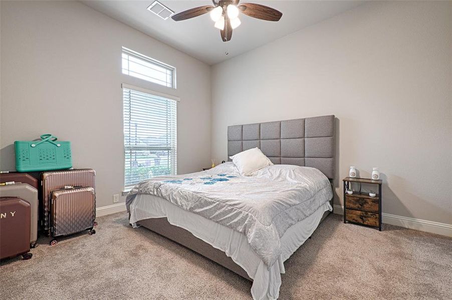 Carpeted bedroom featuring ceiling fan