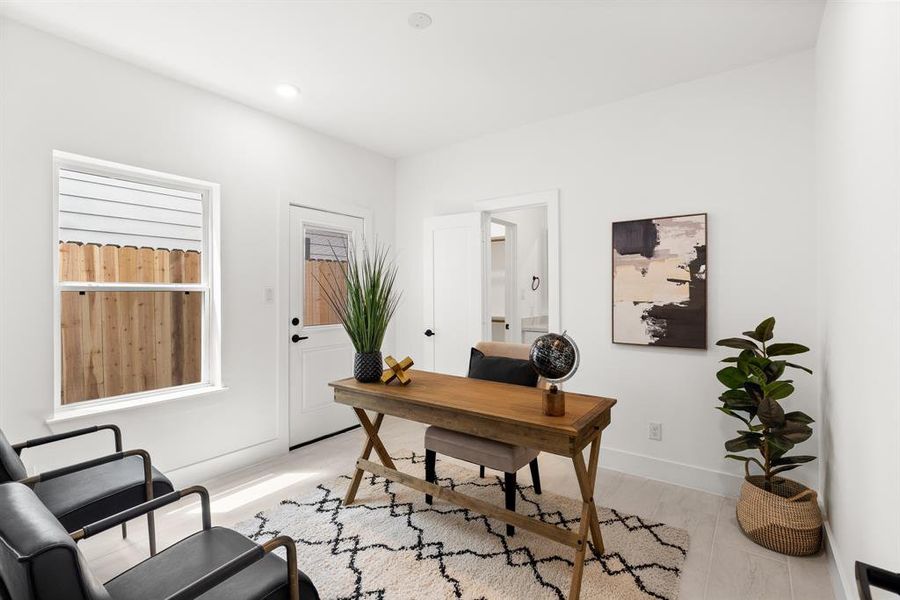 This first-floor bedroom, designed with ample storage, natural lighting, and flexible furniture arrangements, seamlessly transitions from a comfortable and functional office space to a cozy and inviting guest bedroom.