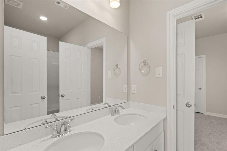 The secondary bath features tile flooring, white cabinetry and light countertops and a shower/tub combo. Perfect for accommodating any visiting family and friends.