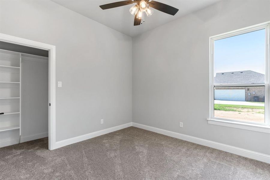 Unfurnished bedroom with carpet, a closet, and ceiling fan