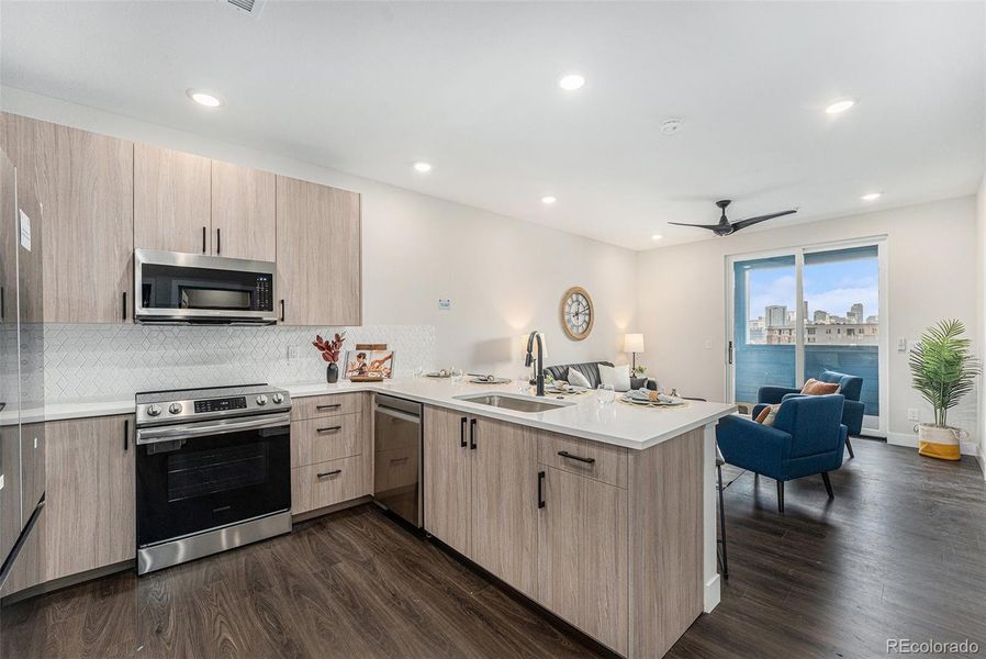 Similar unit staged; kitchen to Living area with outside balcony beyond