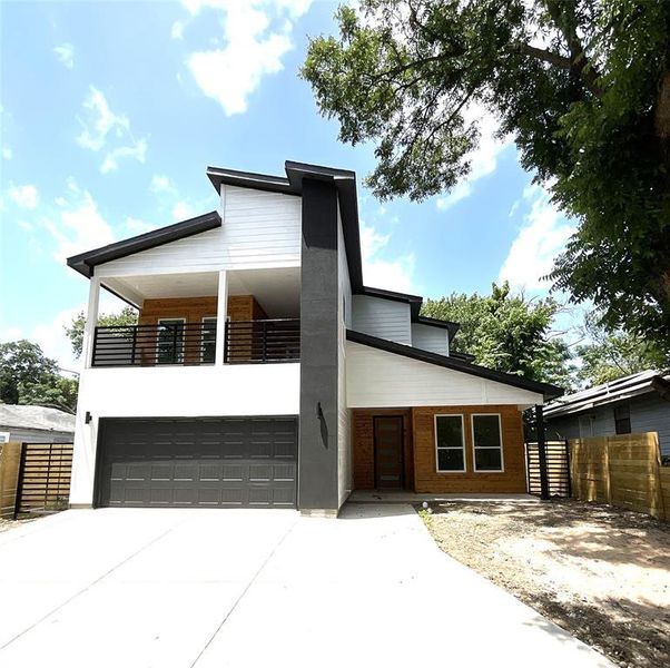 Contemporary house featuring a balcony and a garage