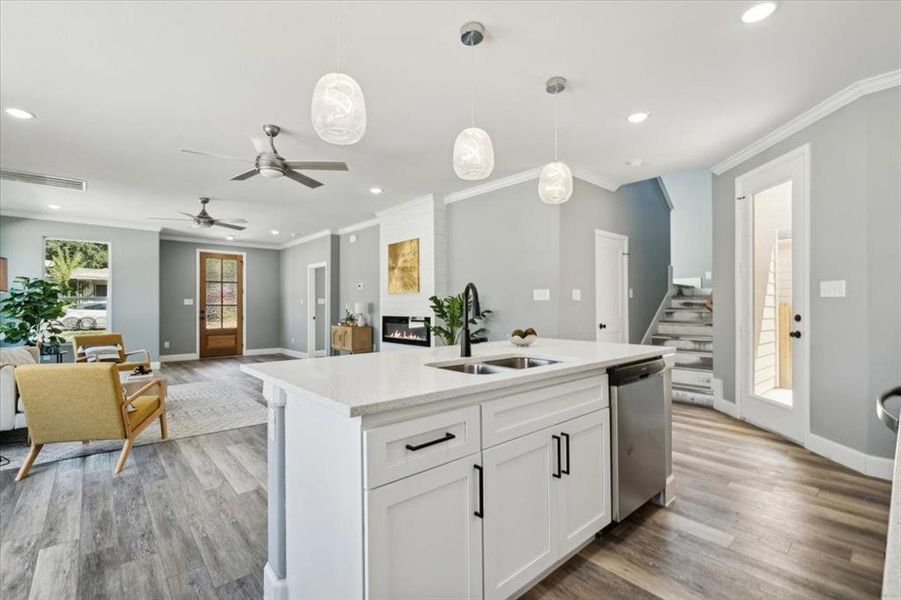 Kitchen featuring sink, white cabinetry, decorative light fixtures, ceiling fan, and stainless steel dishwasher