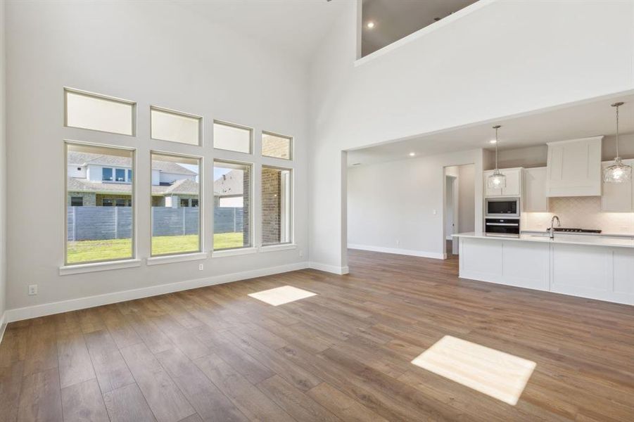 Unfurnished living room featuring high vaulted ceiling and wood-type flooring