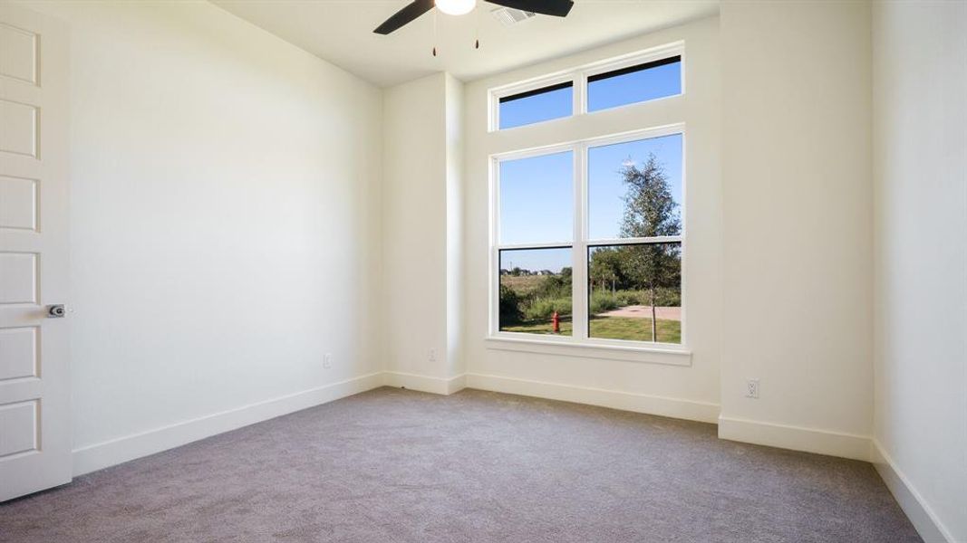 Carpeted empty room with ceiling fan