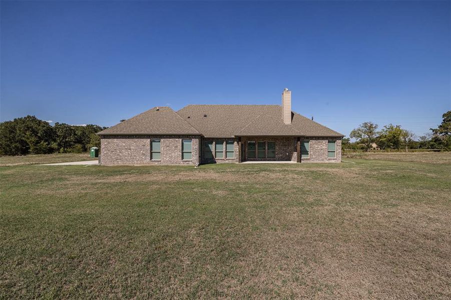 Rear view of house featuring a lawn