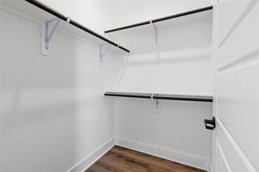 This view showcases the well-organized closet in the third bedroom, featuring three hanging systems for efficient storage