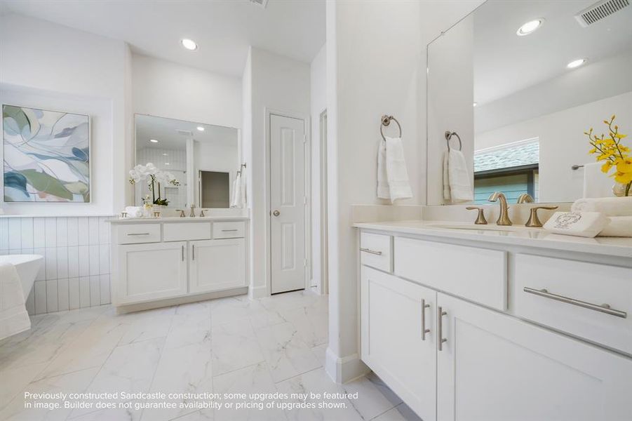 Spa-like Splendor: Dual vanities, a roomy linen closet, and a secluded water closet are set amid abundant space for an everyday spa experience right at home.