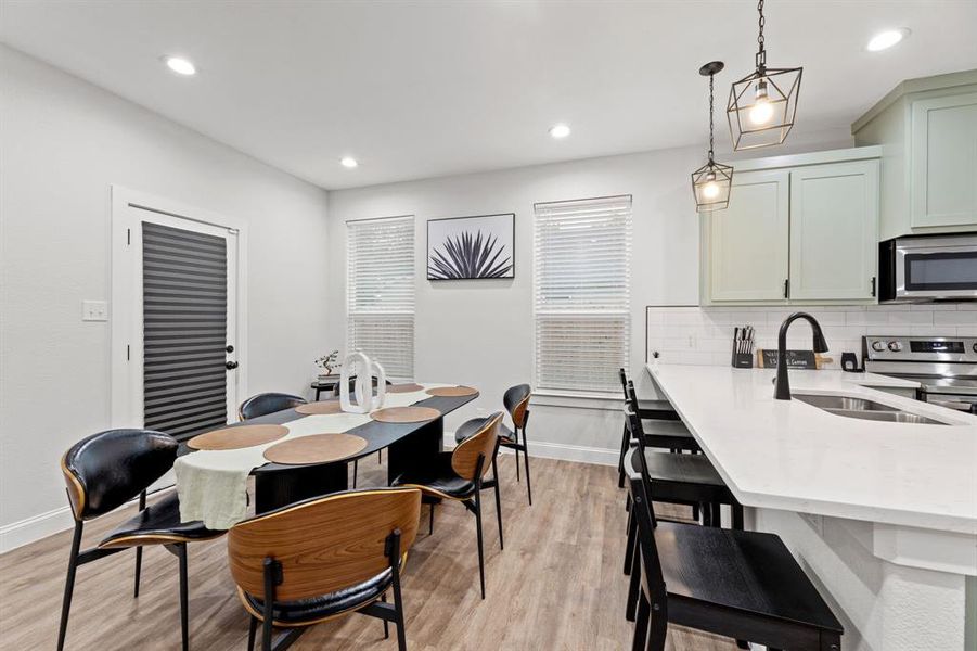 Dining area with sink and light wood-type flooring