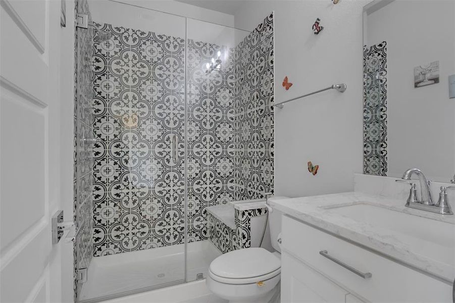Bathroom with a shower with door, large vanity, and toilet
