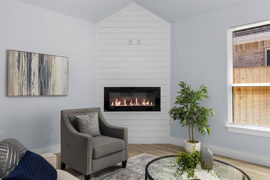 Sitting room with a fireplace and light hardwood / wood-style flooring