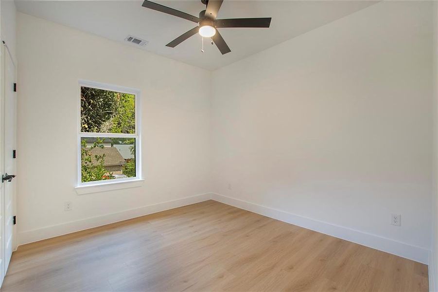 Empty room with light hardwood / wood-style floors and ceiling fan