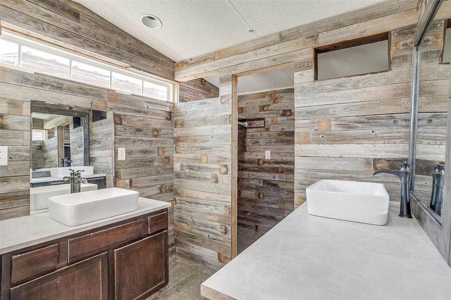 Bathroom with vanity, a healthy amount of sunlight, and wooden walls