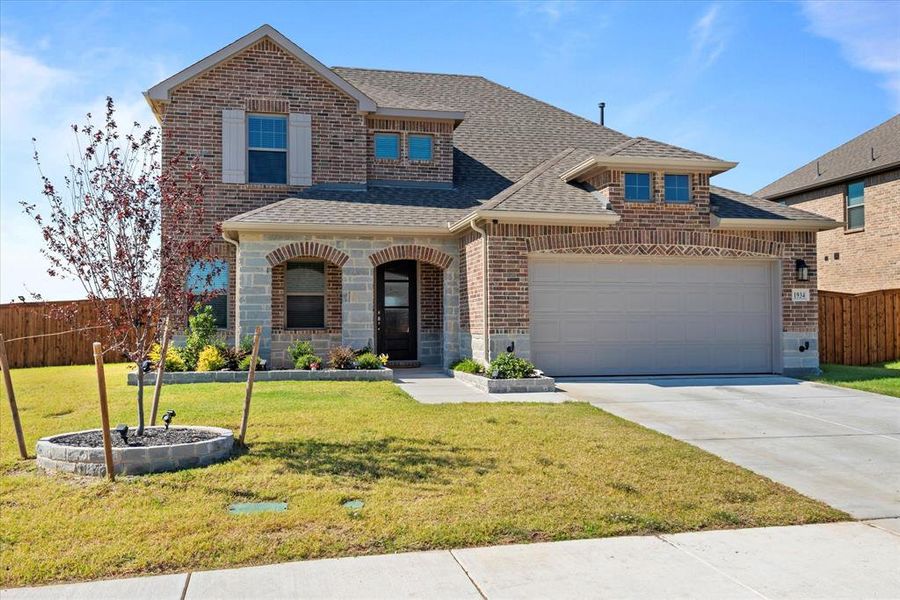 View of front of property with a front yard and a garage