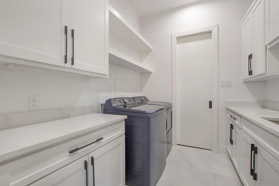 Washroom with cabinets and washing machine and clothes dryer