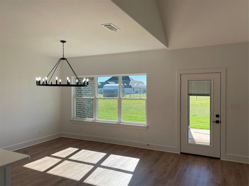 Unfurnished dining area with a chandelier and dark hardwood / wood-style flooring