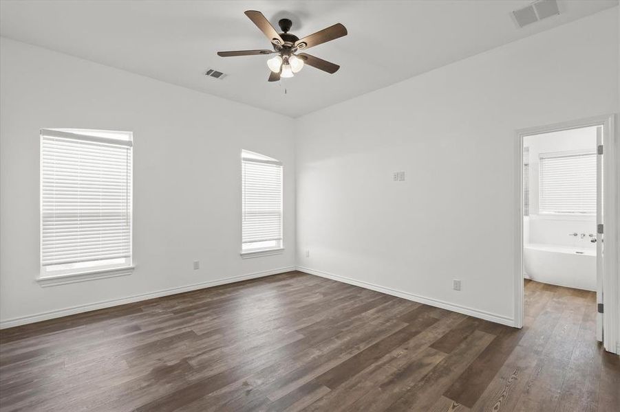 Empty room with dark wood-type flooring and ceiling fan