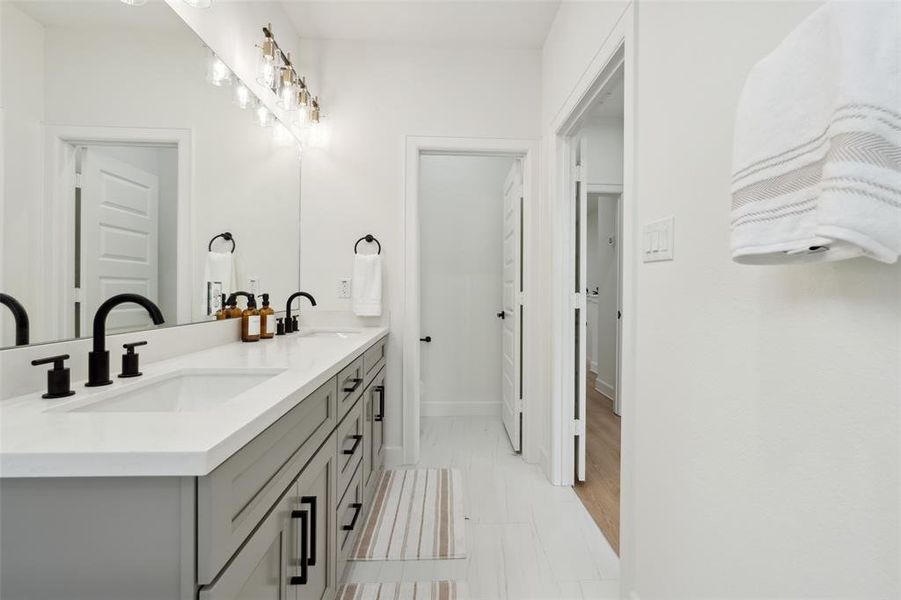 Step into luxury with an ensuite featuring separate sinks and pristine white quartz countertops. This meticulously designed space offers both functionality and elegance, with ample room for your daily routines.